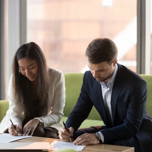 Signing Legal Documents: Man and woman at table.