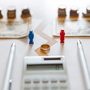 Calculator, wedding ring, and chess pieces, illustrating asset division in a California divorce.