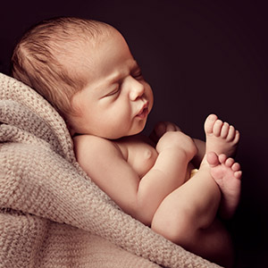 Close-up of a newborn baby wrapped in a blanket, illustrating a legal dispute over Frozen Embryos.