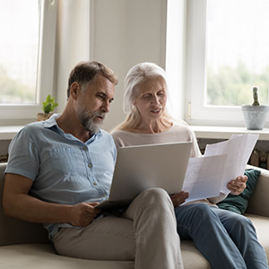 Couple reviewing financial documents and laptop for inheritance division in a California divorce.