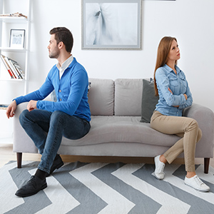 Legal Separation vs. Divorce in California guide with a couple sitting apart on a sofa.